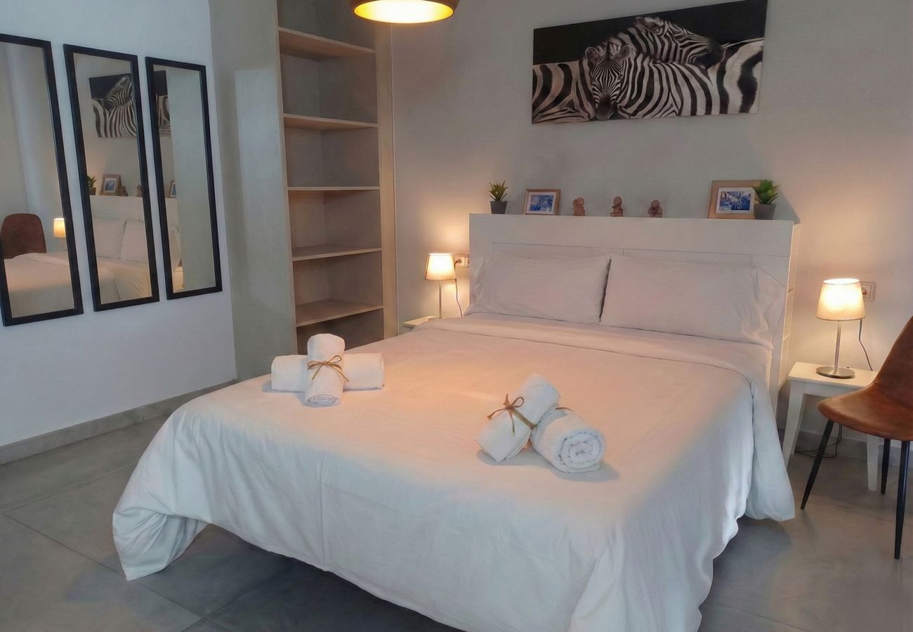 Cama de matrimonio con ropa de cama blanca