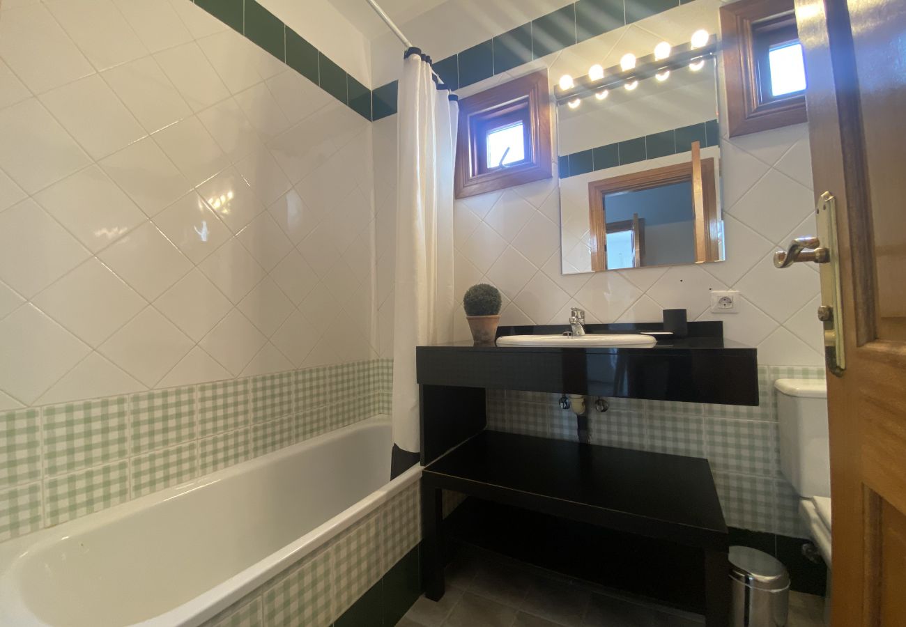 Lavabo sobre mueble negro y espejo grande en Villa Capri