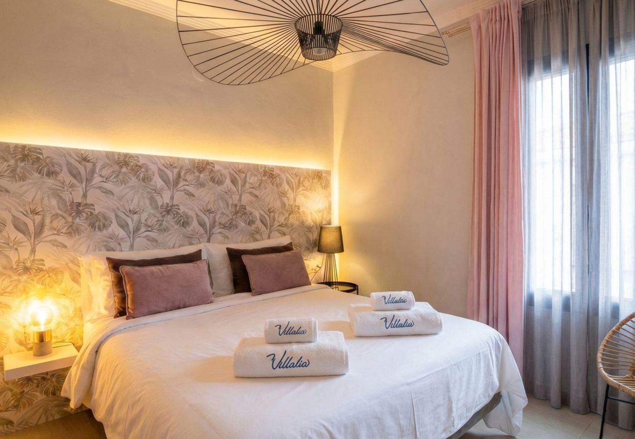 Cama doble con cabecero iluminado y decoración cálida