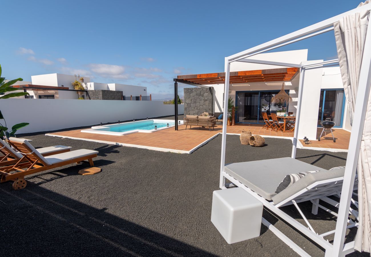 Amplia terraza para disfrutar en vacaciones Terraza villa vacacional con piscina, cama balinesa y mobiliario exterior
