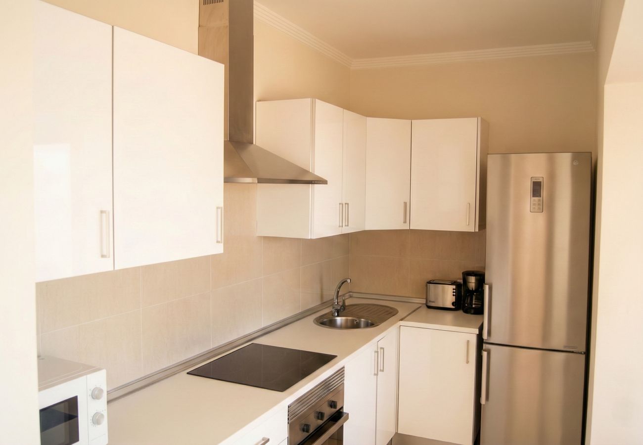 Cocina blanca con nevera y armarios