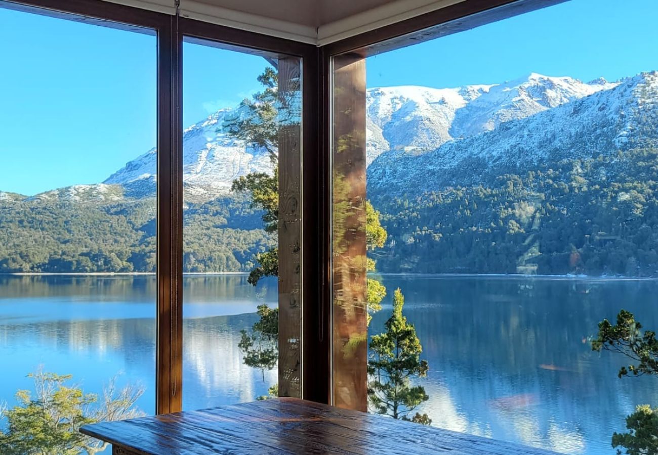 Área de living del Salón de Usos Múltiples de Suites del Lago con vistas panorámicas al lago en Bariloche.