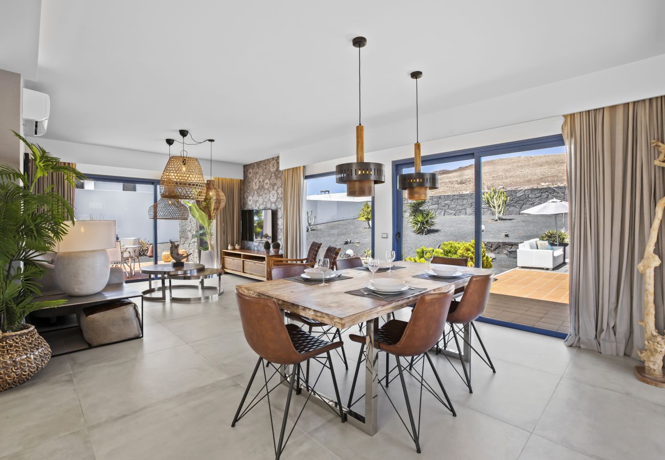 Modern living dining room with plant decor and wicker lamps
