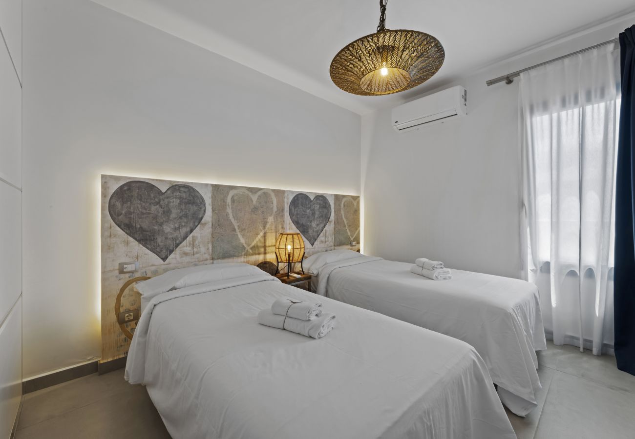 Single beds with heart decoration on wall