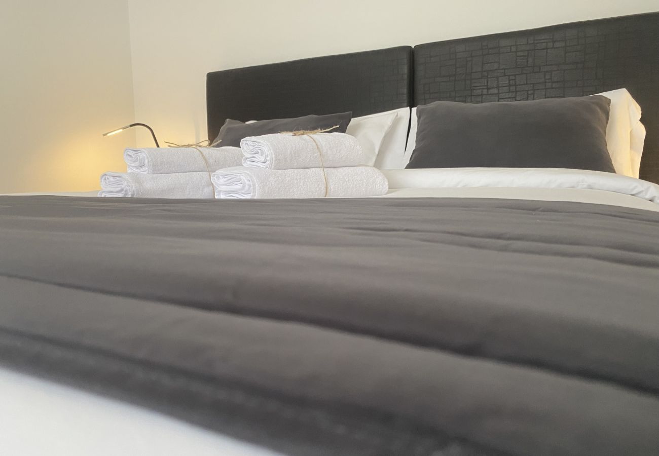 Detail of bed dressed with grey cushions at Villa Capri