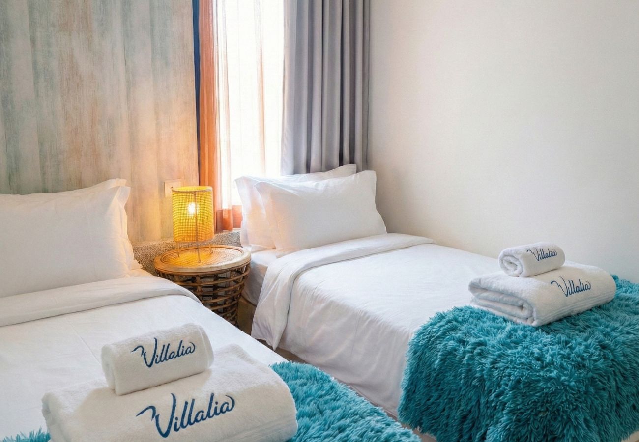 Two single beds with turquoise blankets
