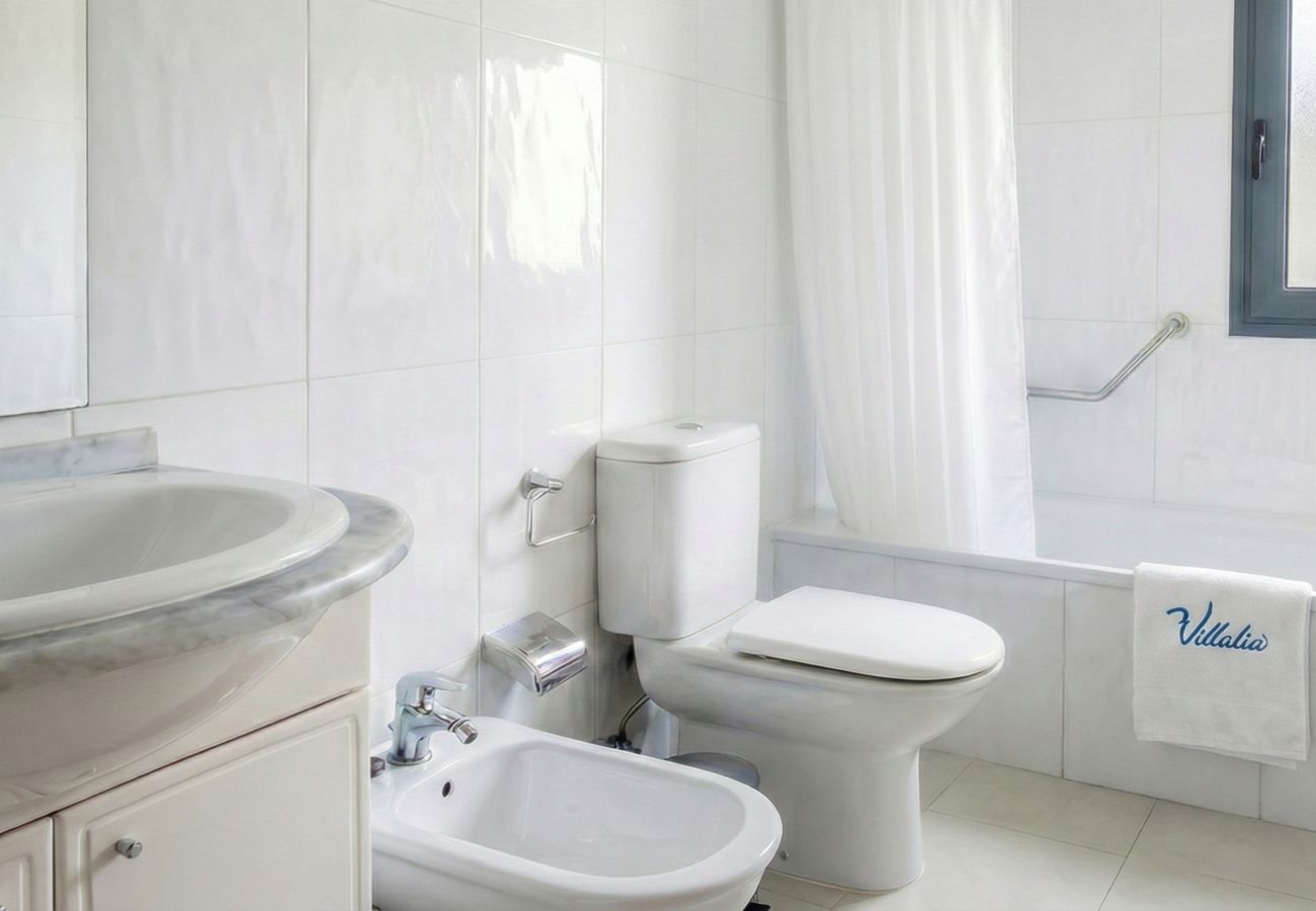 White bathroom with toilet, bidet, and sink