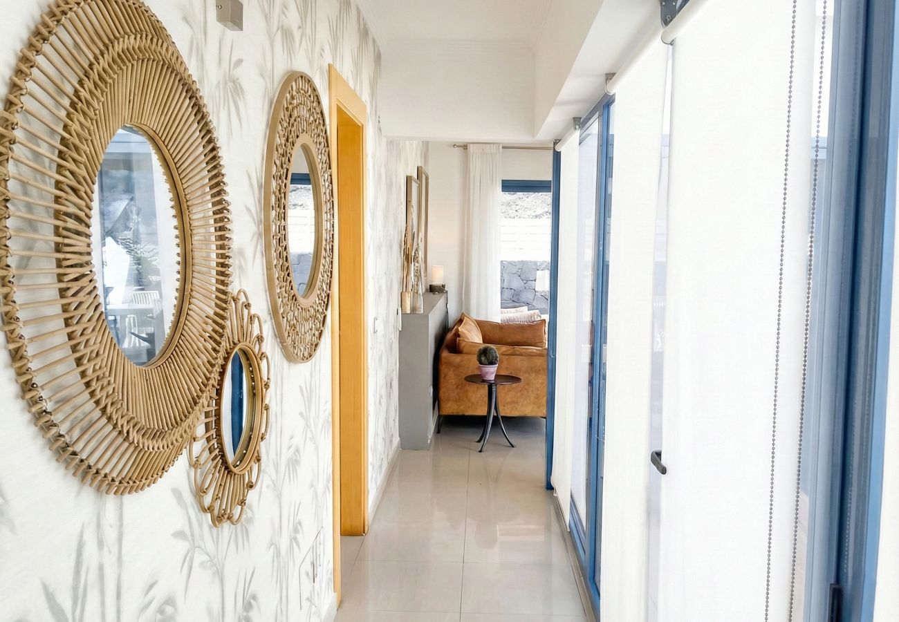 White interior hallway with three wicker mirrors on the wall