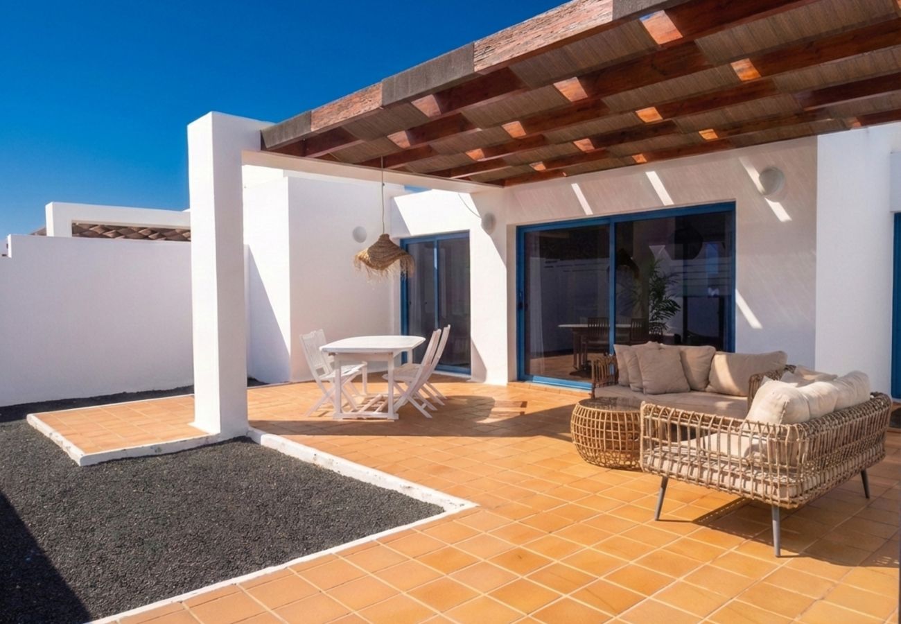 Outdoor sofas and coffee table under wooden pergola