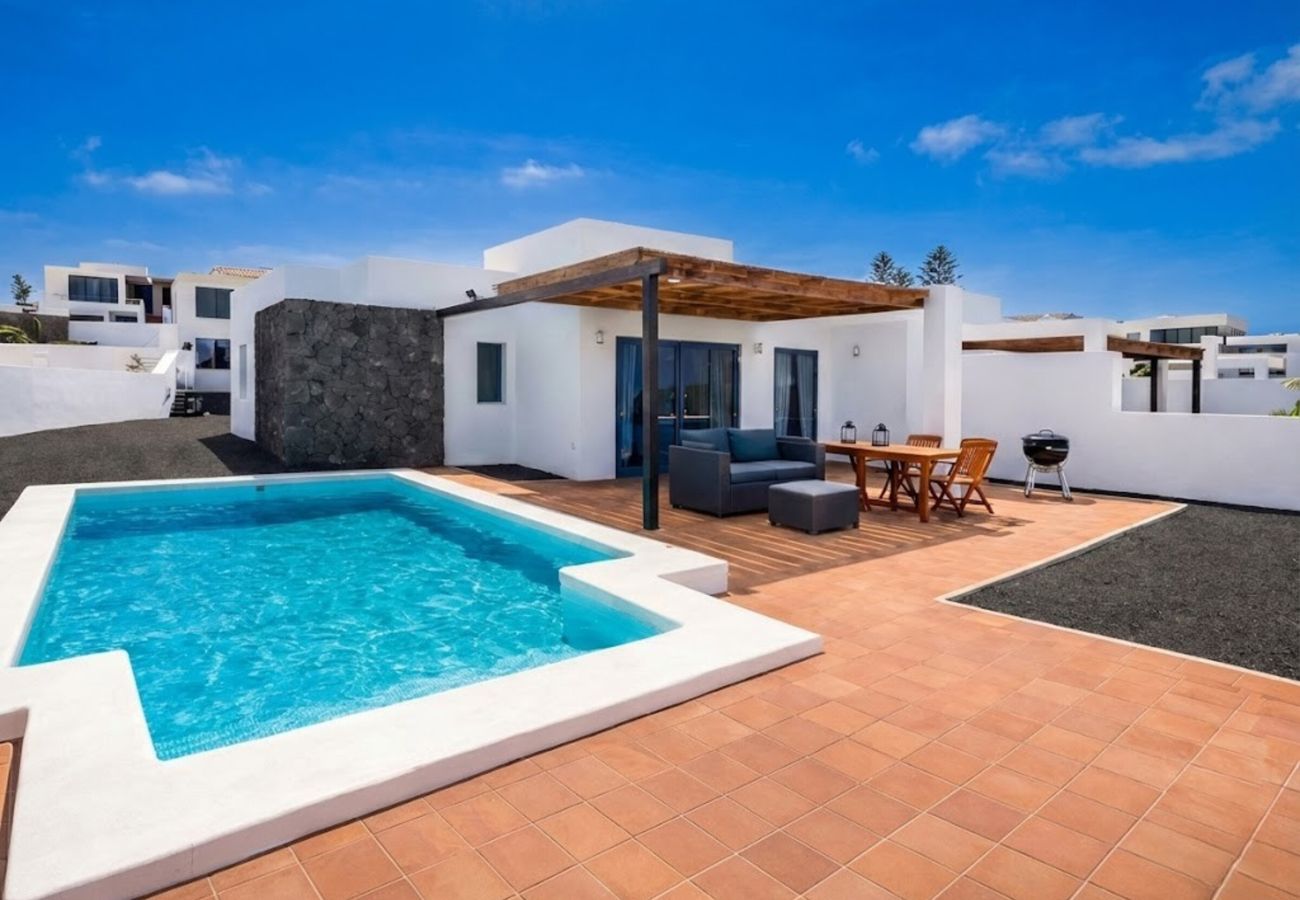 Turquoise pool and terrace with pergola and outdoor furniture at Villa Gaumet, Lanzarote.