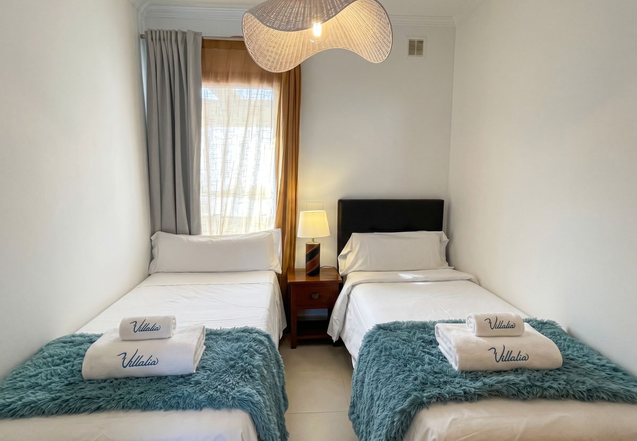 Bright second bedroom with two comfortable single beds.