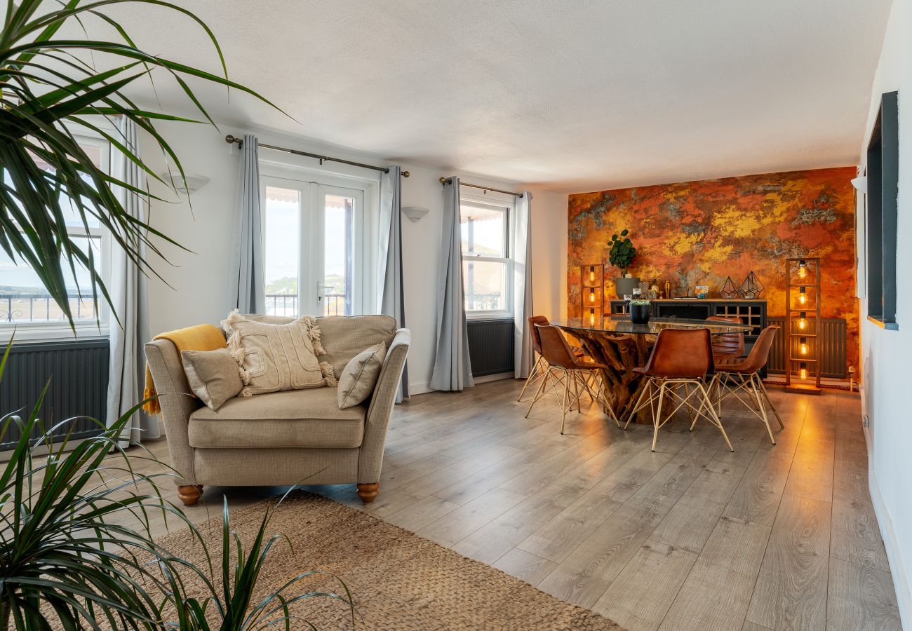 Dining area in The Crab Shack apartment with doors leading to balcony and sea view