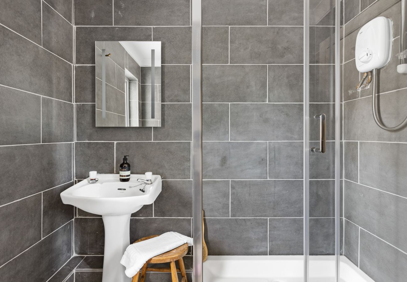 Shower room in Bramblewood with grey brick-style tiles and white suite