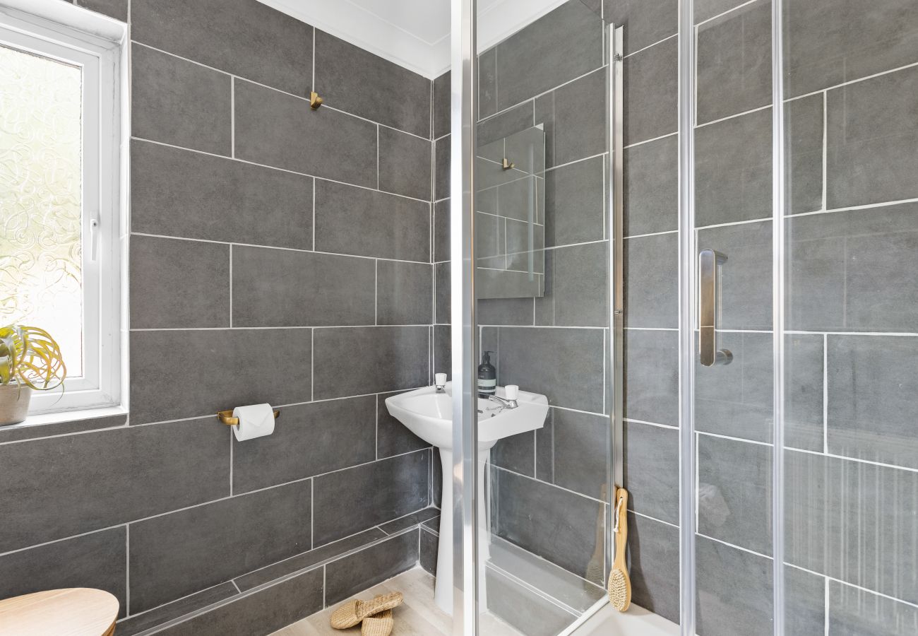 Shower room in Bramblewood with grey brick-style tiles and white suite