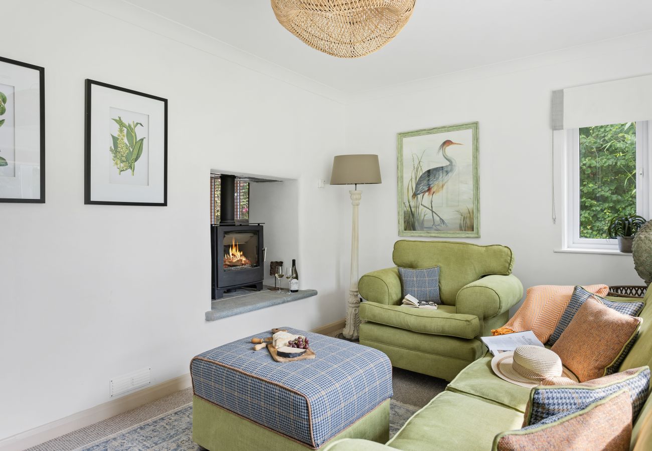 Living room in Bramblewood cottage with double-sided fireplace and wood stove
