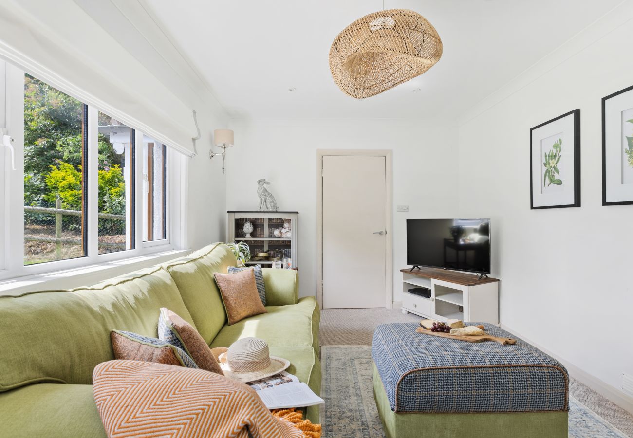 Living room in Bramblewood cottage with double-sided fireplace and wood stove”